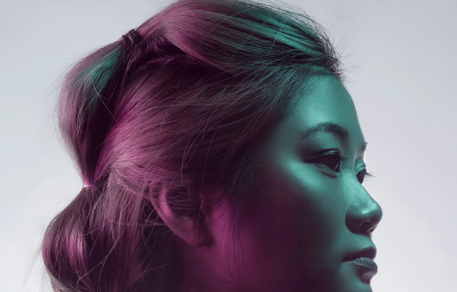 Model in coloured studio light with a sculpted updo