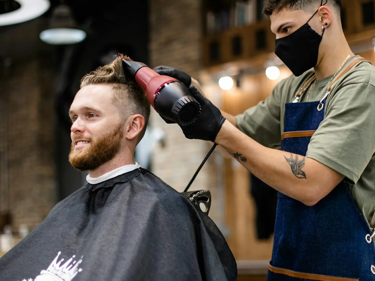 Barber finishing a cut with a dryer