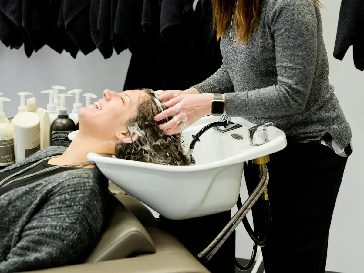Stylist washing a client's hair